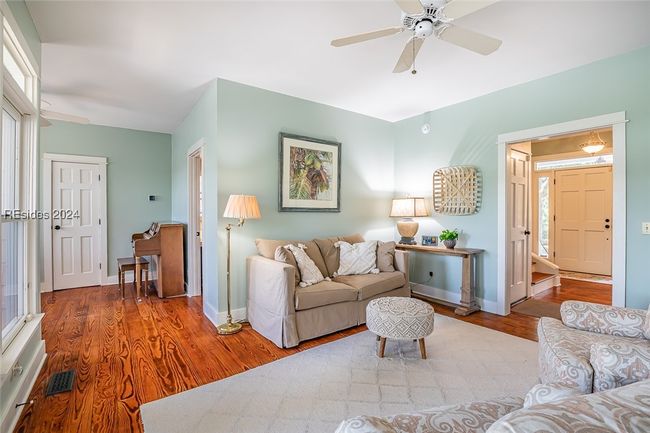 Living room featuring hardwood / wood-style flooring, ceiling fan, and a wealth of natural light | Image 13