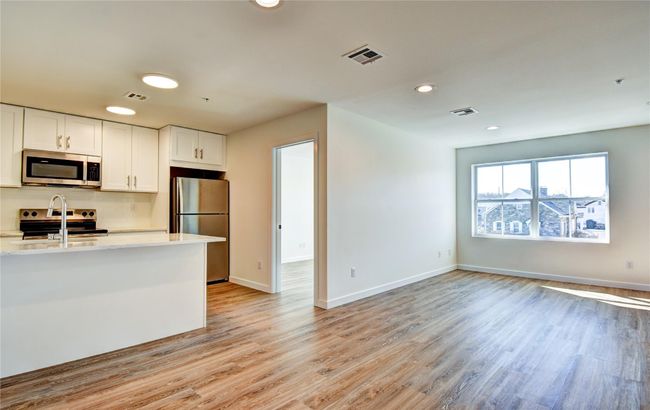 Kitchen with visible vents, white cabinetry, appliances with stainless steel finishes, and light wood finished floors | Image 28