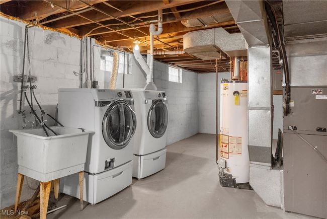 Laundry area featuring heating unit, washer and clothes dryer, and water heater | Image 16