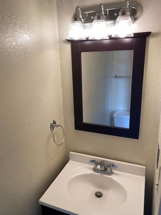 Bathroom featuring a textured wall and vanity | Image 6