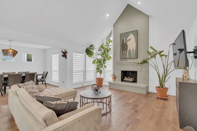 Living area featuring a fireplace, recessed lighting, baseboards, wood finished floors, and lofted ceiling | Image 8