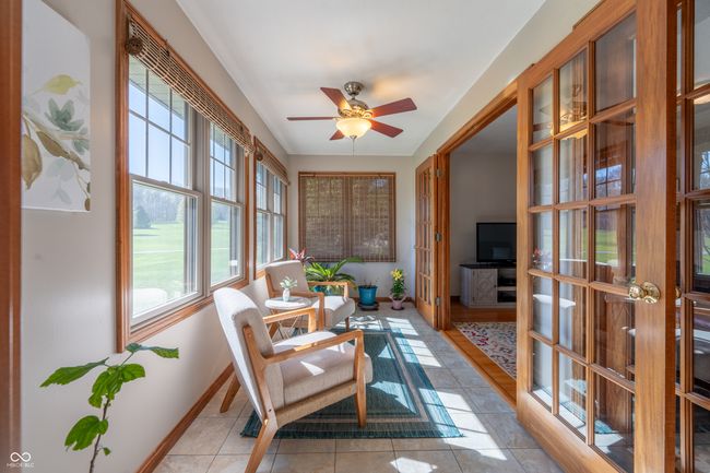 sunroom featuring french doors, baseboards, tile patterned flooring, and a healthy amount of sunlight | Image 7