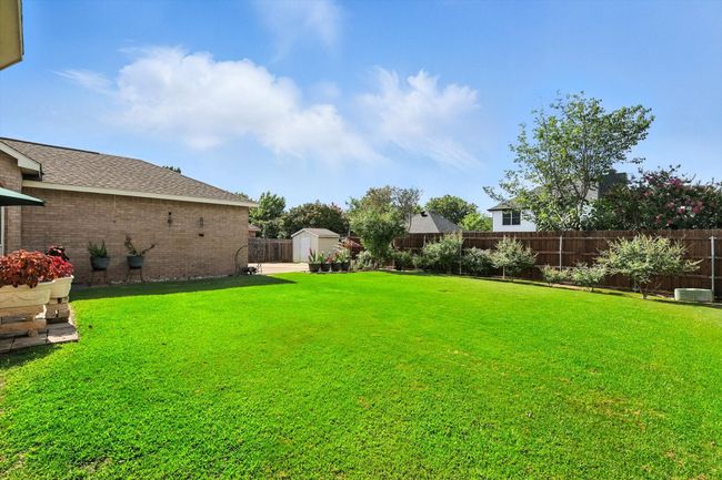 Fenced backyard featuring a shed | Image 29