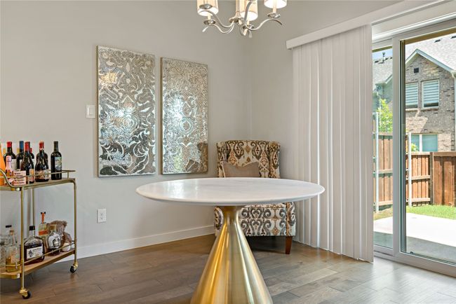 Dining area with hardwood / wood-style floors, an inviting chandelier, and bar | Image 10
