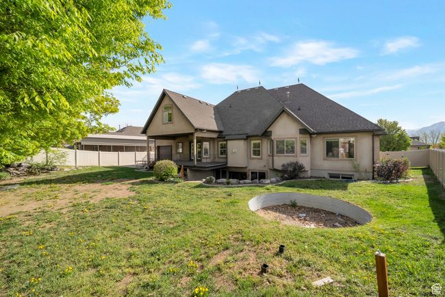 Rear view of property featuring a yard, a fenced backyard, and roof with shingles | Image 49