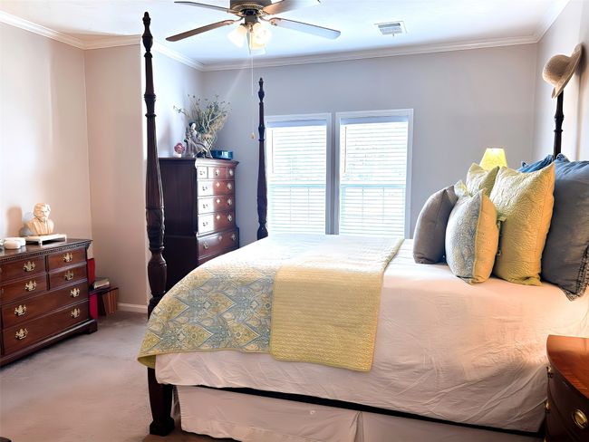 Bedroom with light carpet, visible vents, crown molding, and ceiling fan | Image 5