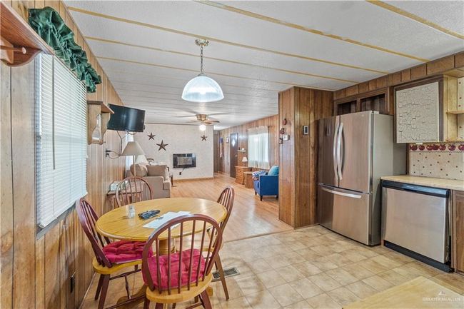 Dining area with wood walls and a ceiling fan | Image 8