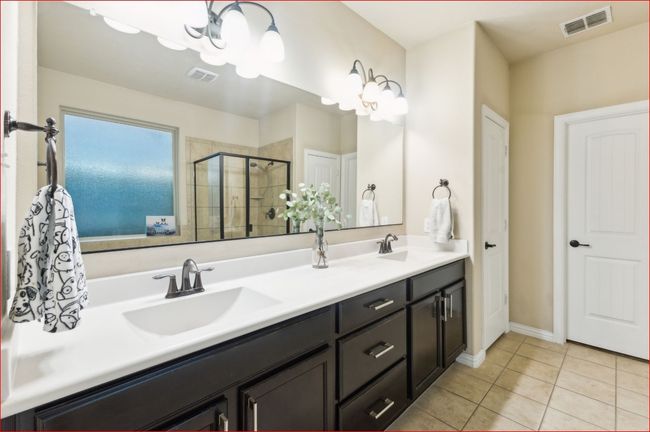 Bathroom featuring double vanity, tile patterned flooring, a stall shower, and a chandelier | Image 18