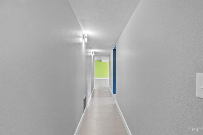 Corridor featuring a textured ceiling and baseboards | Image 30