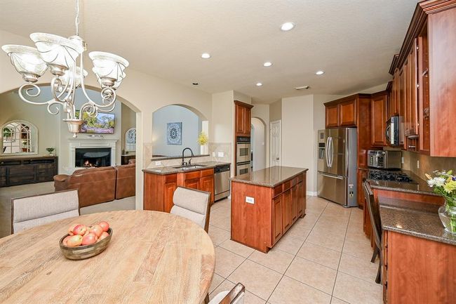 Open-concept, island kitchen with granite countertops and stainless appliances. | Image 8