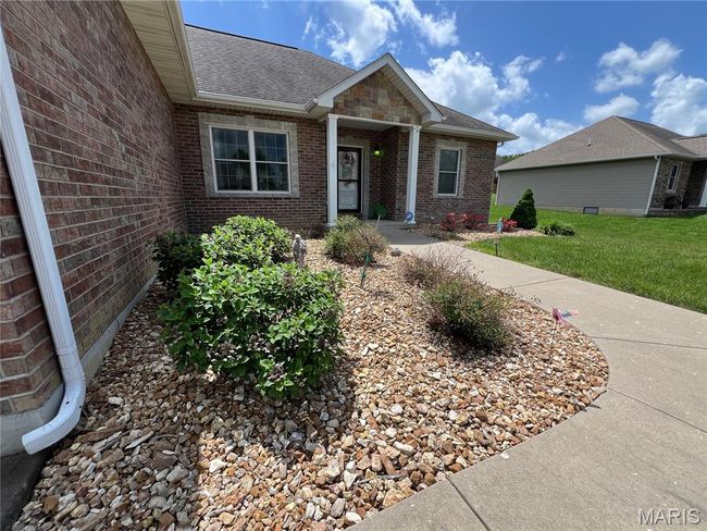 View of front of house with a shingled roof, brick siding, and a front lawn | Image 5