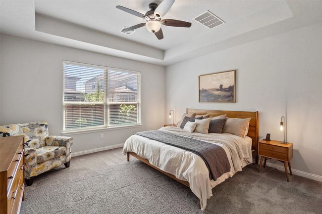 Carpeted bedroom with a tray ceiling and a ceiling fan | Image 15