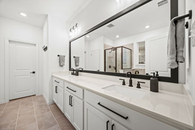 Bathroom featuring double vanity, a shower stall, recessed lighting, tile patterned floors, and baseboards | Image 18