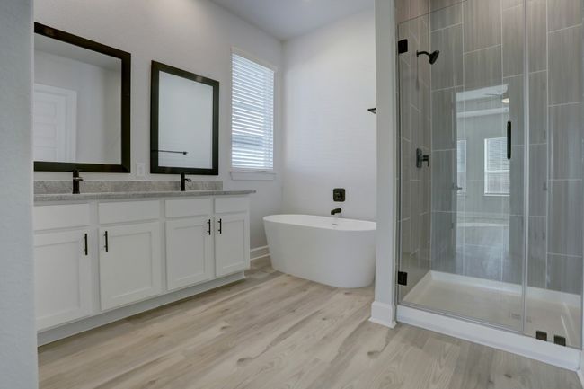 the primary bath features a large soaking tub, walk-in shower, double-sink vanity, and walk-in closet. | Image 6