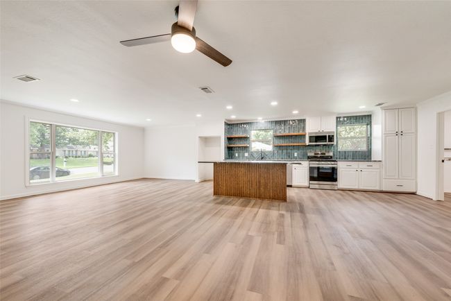 Unfurnished living room featuring a ceiling fan, light wood finished floors, and recessed lighting | Image 10