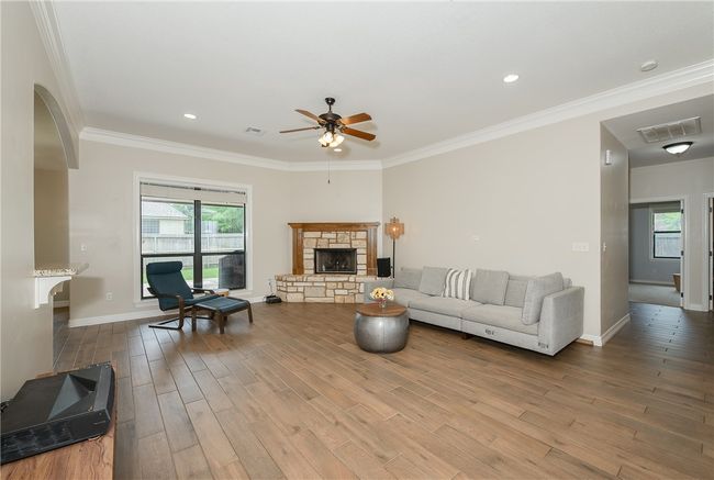 Living area featuring a wealth of natural light, visible vents, and ceiling fan | Image 4