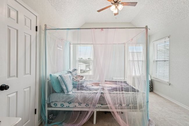 Bedroom featuring vaulted ceiling, a textured ceiling, multiple windows, carpet flooring, and a ceiling fan | Image 26