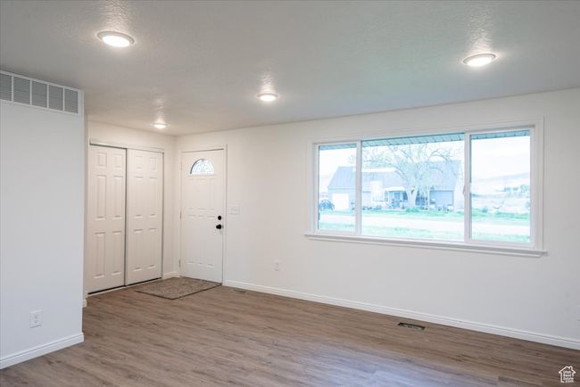 Foyer entrance featuring baseboards, visible vents, and wood finished floors | Image 6