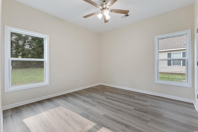 Spare room with plenty of natural light, wood finished floors, and a ceiling fan | Image 21