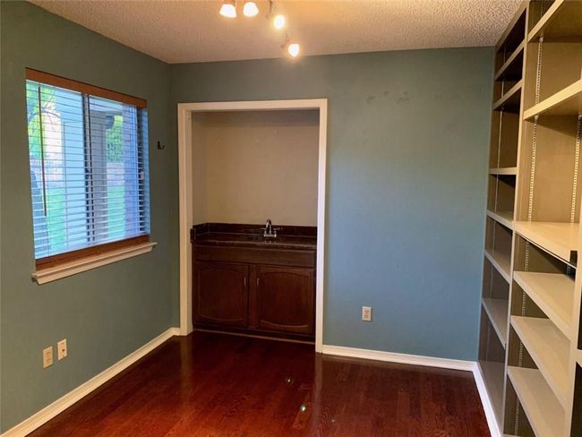 Unfurnished Study with dark wood finished floors, baseboards, a sink, and a textured ceiling | Image 14