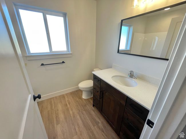 Bathroom featuring baseboards, wood finished floors, toilet, and vanity | Image 10