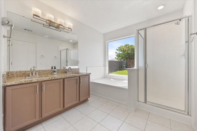 Bathroom featuring a shower stall, a garden tub, double vanity, a textured ceiling, and tile patterned floors | Image 17