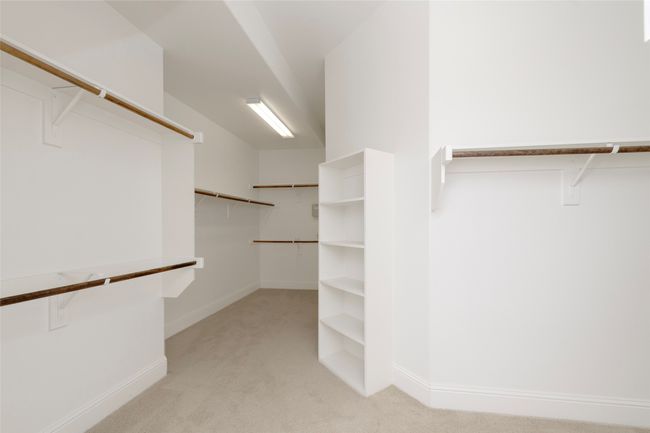 Walk in closet featuring light carpet | Image 21