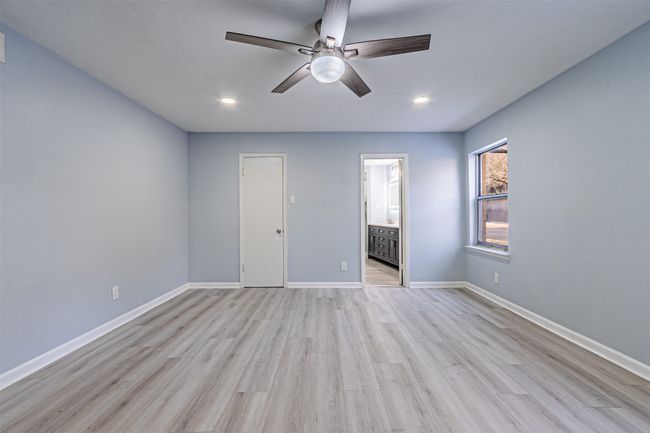 Unfurnished bedroom featuring connected bathroom, light hardwood / wood-style floors, and ceiling fan | Image 29