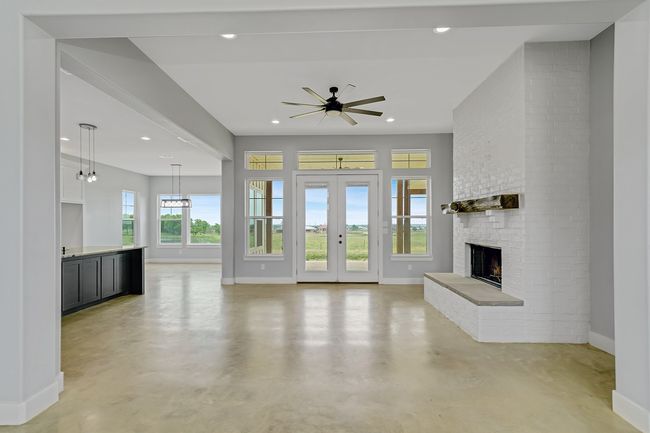 Unfurnished living room featuring concrete floors, baseboards, a fireplace, recessed lighting, and ceiling fan | Image 5