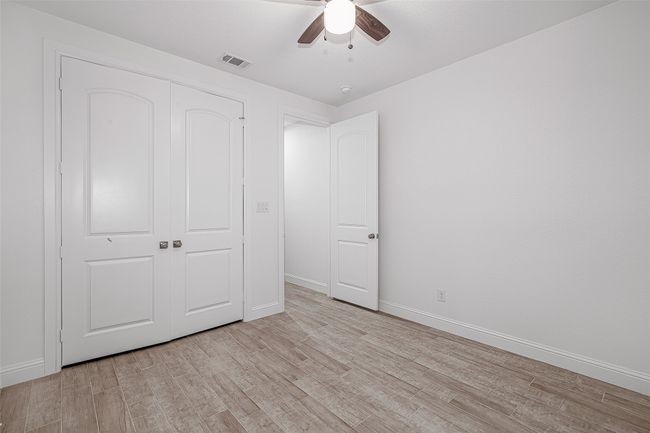 Unfurnished bedroom featuring light wood-type flooring, baseboards, a closet, and ceiling fan | Image 13