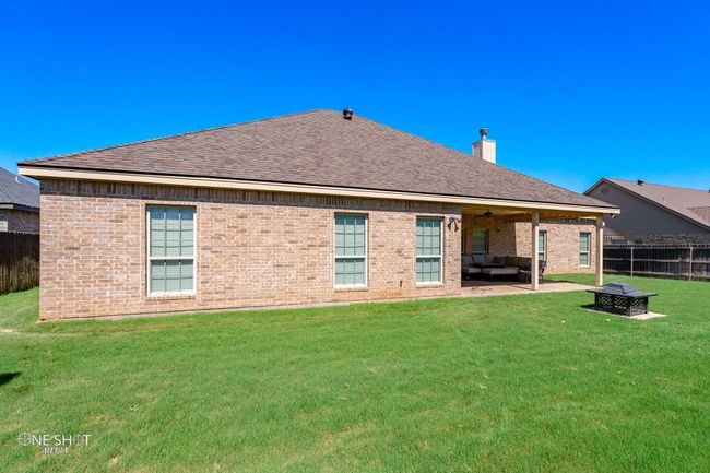 Rear view of house featuring an outdoor hangout area, a chimney, roof with shingles, a ceiling fan, and a patio | Image 38