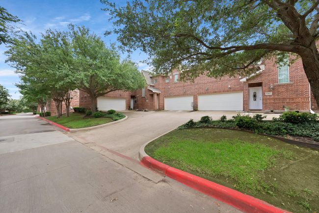 View of front of home with driveway, brick siding, and an attached garage | Image 4