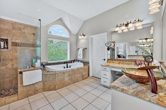 Bathroom featuring a garden tub, walk in shower, vanity, tile patterned floors, and lofted ceiling | Image 21
