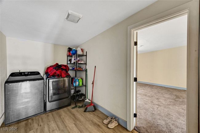 Laundry area with washer and dryer and wood finished floors | Image 19