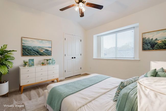 Upstairs Bedroom featuring a ceiling fan, baseboards, vaulted ceiling, a closet, and light colored carpet | Image 22