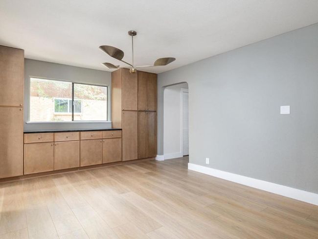 Unfurnished room with light wood-style flooring, arched walkways, and ceiling fan | Image 12