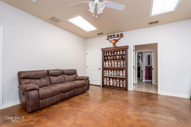 Living area with ceiling fan, concrete floors, baseboards, and lofted ceiling | Image 33