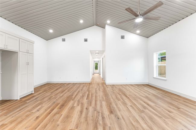 Unfurnished living room featuring high vaulted ceiling, a ceiling fan, light wood-style flooring, recessed lighting, and baseboards | Image 8
