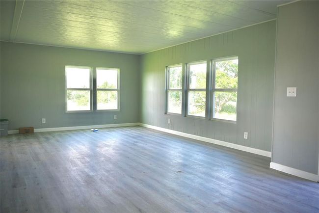 Empty room featuring plenty of natural light, wood finished floors, and baseboards | Image 5
