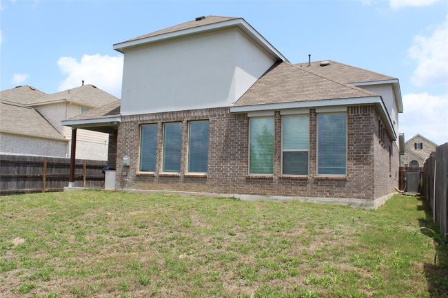 Back of house featuring brick siding, central air condition unit, a shingled roof, and stucco siding | Image 31