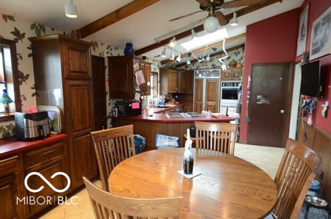 dining space featuring lofted ceiling with beams and ceiling fan | Image 10