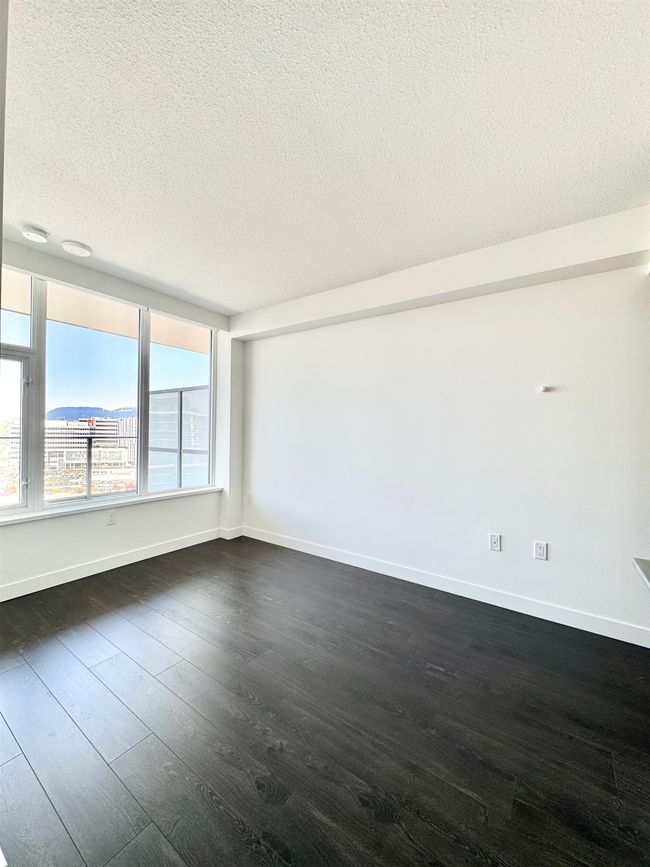 Empty room with baseboards, a textured ceiling, and dark wood-style floors | Image 12