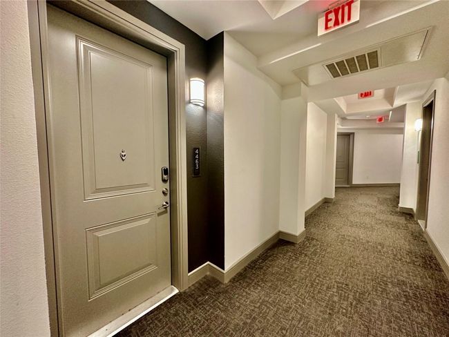 Hallway featuring a tray ceiling and carpet flooring | Image 13