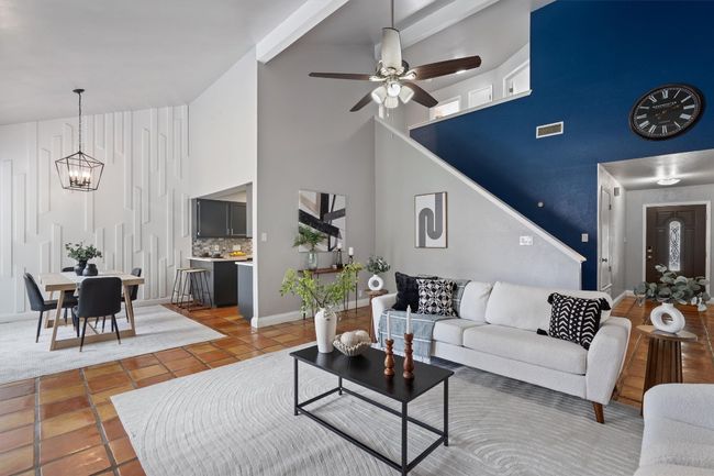 Tiled living area with high vaulted ceiling, a chandelier, and a ceiling fan | Image 5