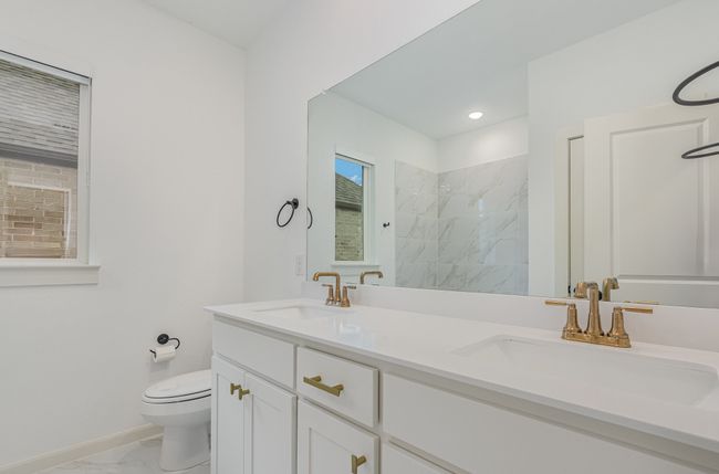 Bathroom featuring marble look tiles, double vanity, and a marble finish shower | Image 24