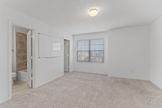 Unfurnished bedroom with baseboards, ensuite bath, and light colored carpet | Image 22
