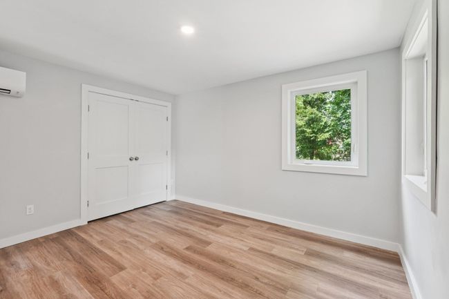 1st fl bedroom featuring light wood-style flooring, a closet, AC/Heat mini split.recessed lighting | Image 11