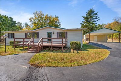 Manufactured home with a front yard, a wooden deck, and a carport | Image 2