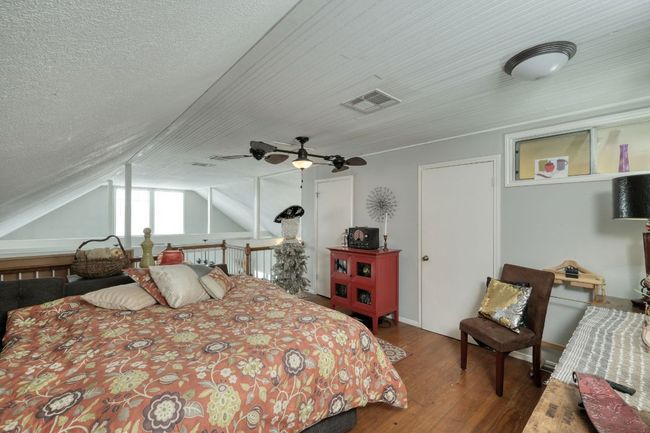 Bedroom with wood finished floors, a ceiling fan, and lofted ceiling | Image 24