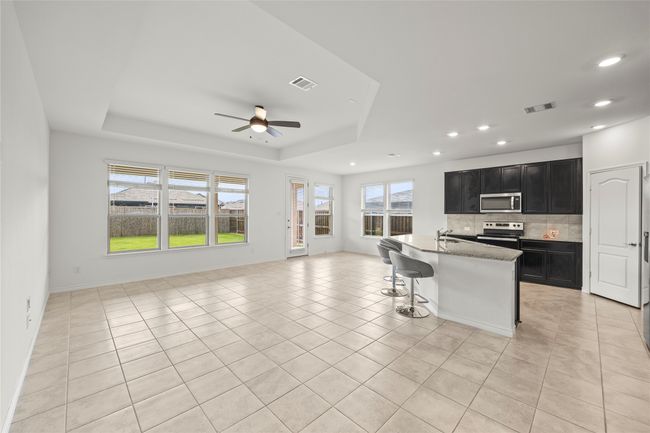 Kitchen featuring appliances with stainless steel finishes, dark cabinets, open floor plan, a sink, and recessed lighting | Image 11